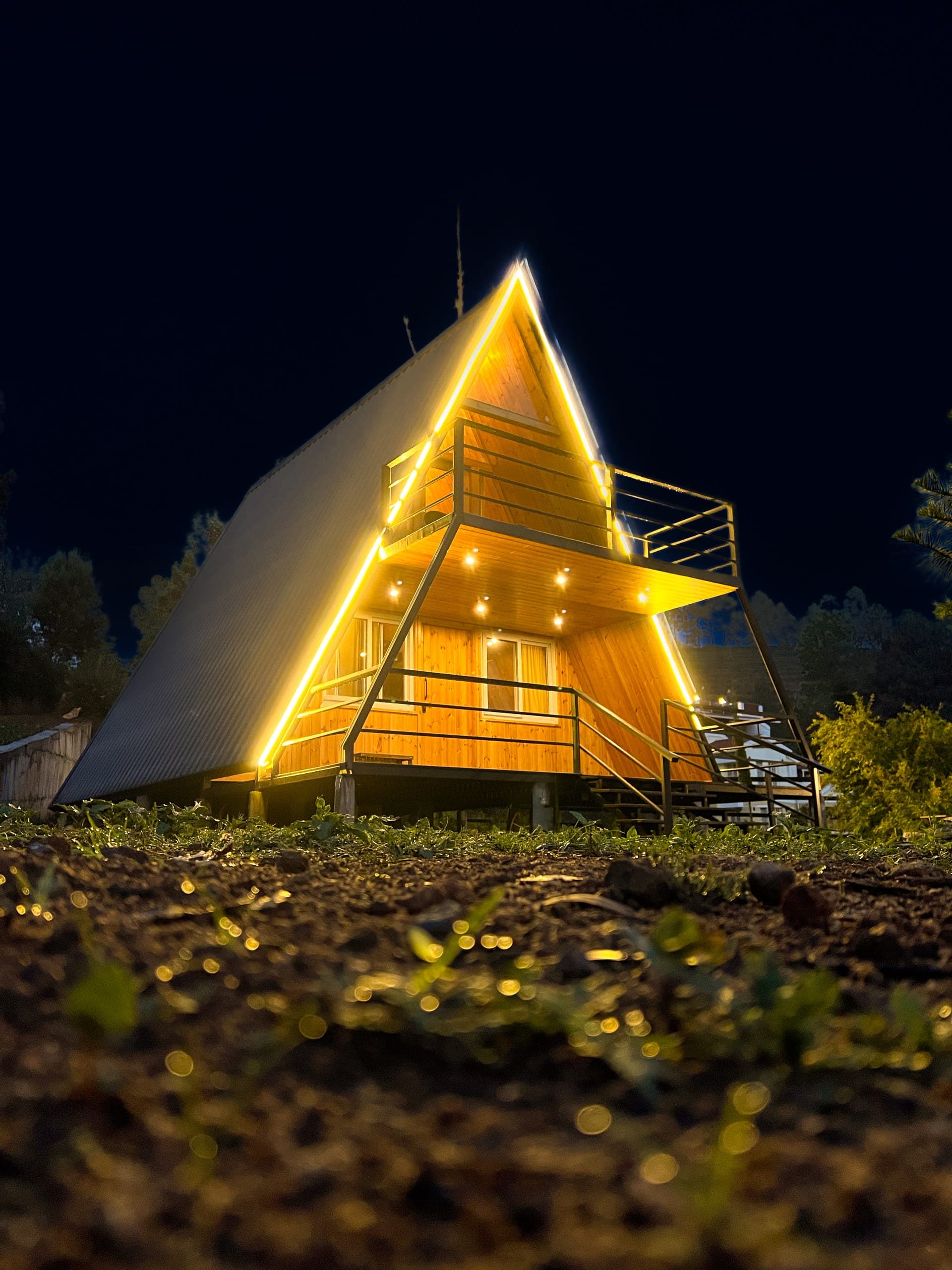 Bonfire, stars, and a lit A-frame